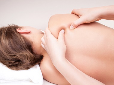 Deep tissue massage on a woman’s  shoulder blade